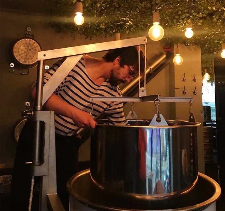 debut-brassin-biere-atelier-min Un élève brasseur en train de brasser de la bière